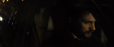 a man sitting in a car in the dark