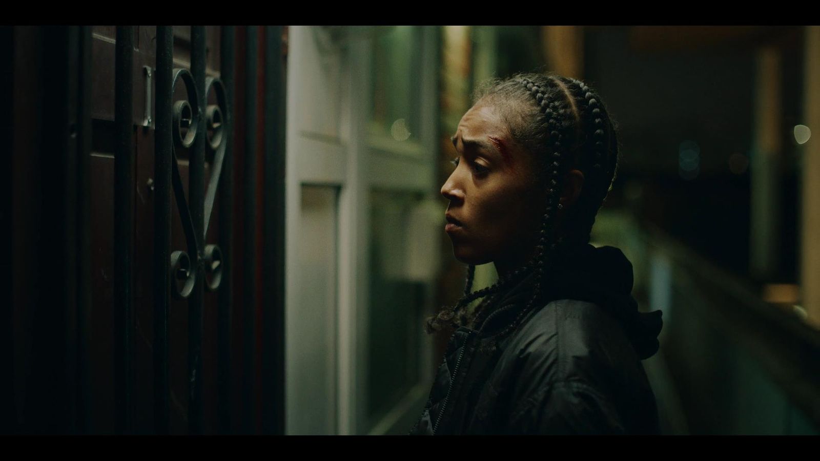 a woman with braids standing next to a door