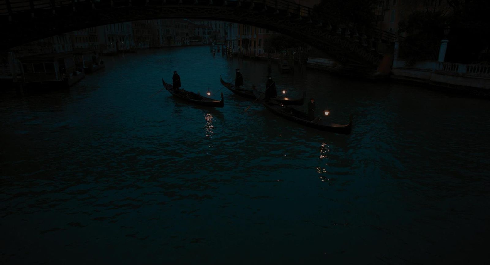 a couple of boats floating down a river under a bridge