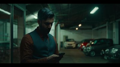 a man standing in a parking garage looking at his cell phone