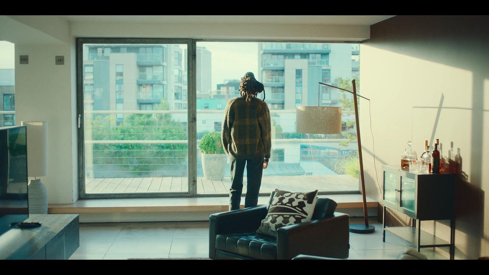 a man standing in a living room next to a window