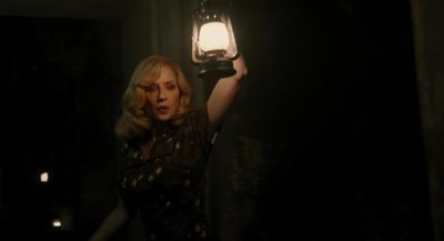 a woman holding a lantern in a dark room