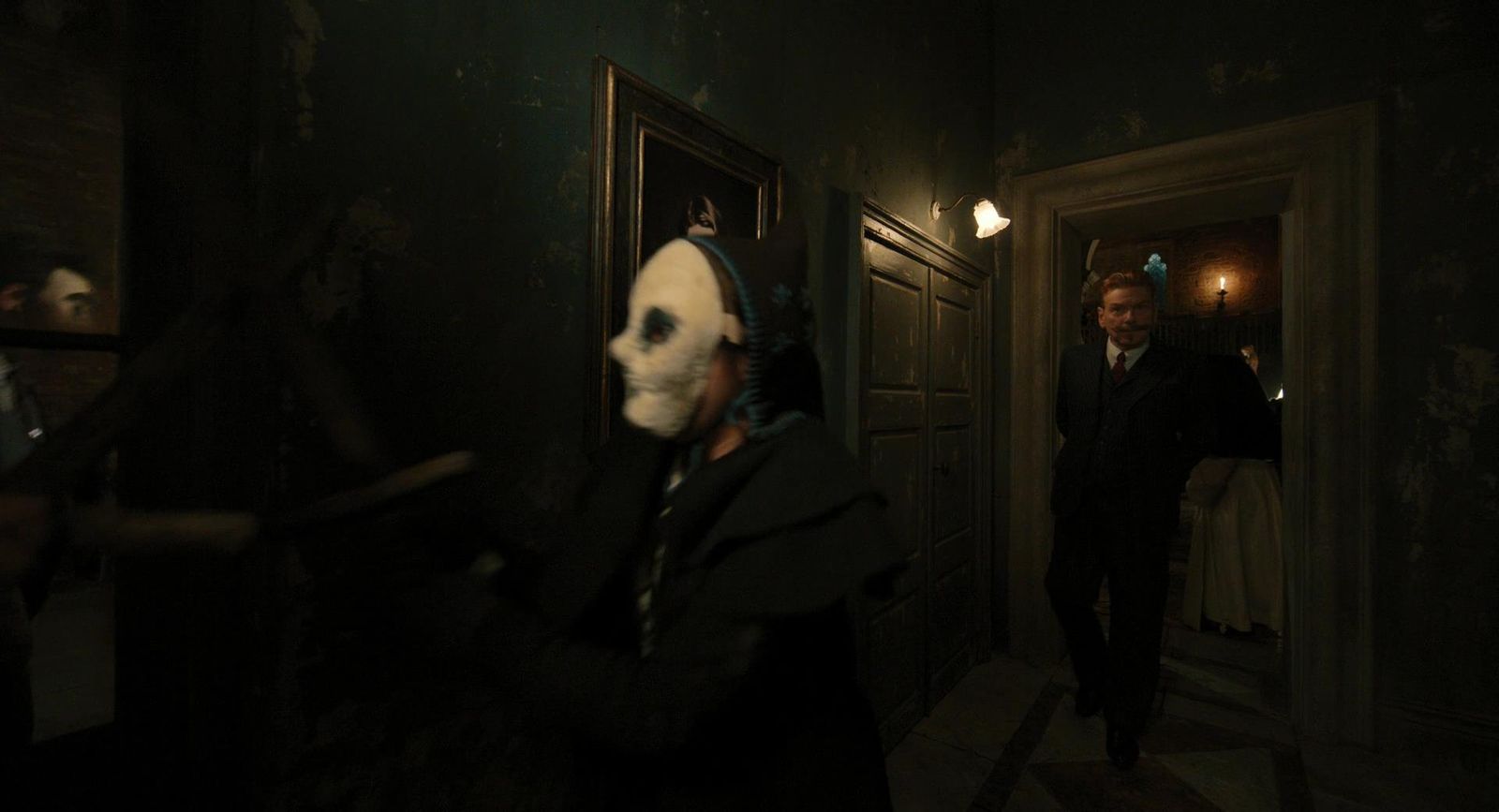 a man in a mask is walking down a hallway