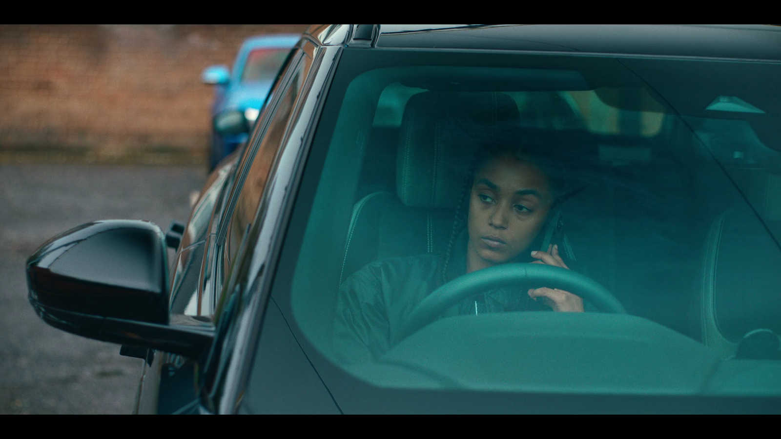 a woman sitting in a car talking on a cell phone