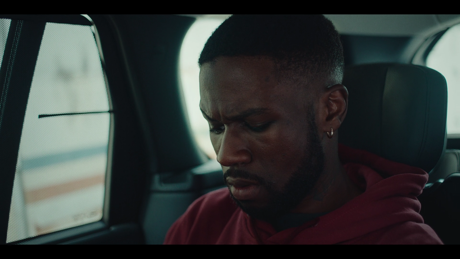 a man sitting in a car looking at his cell phone