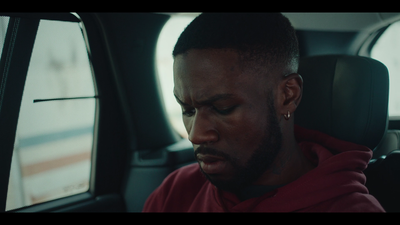 a man sitting in a car looking at his cell phone