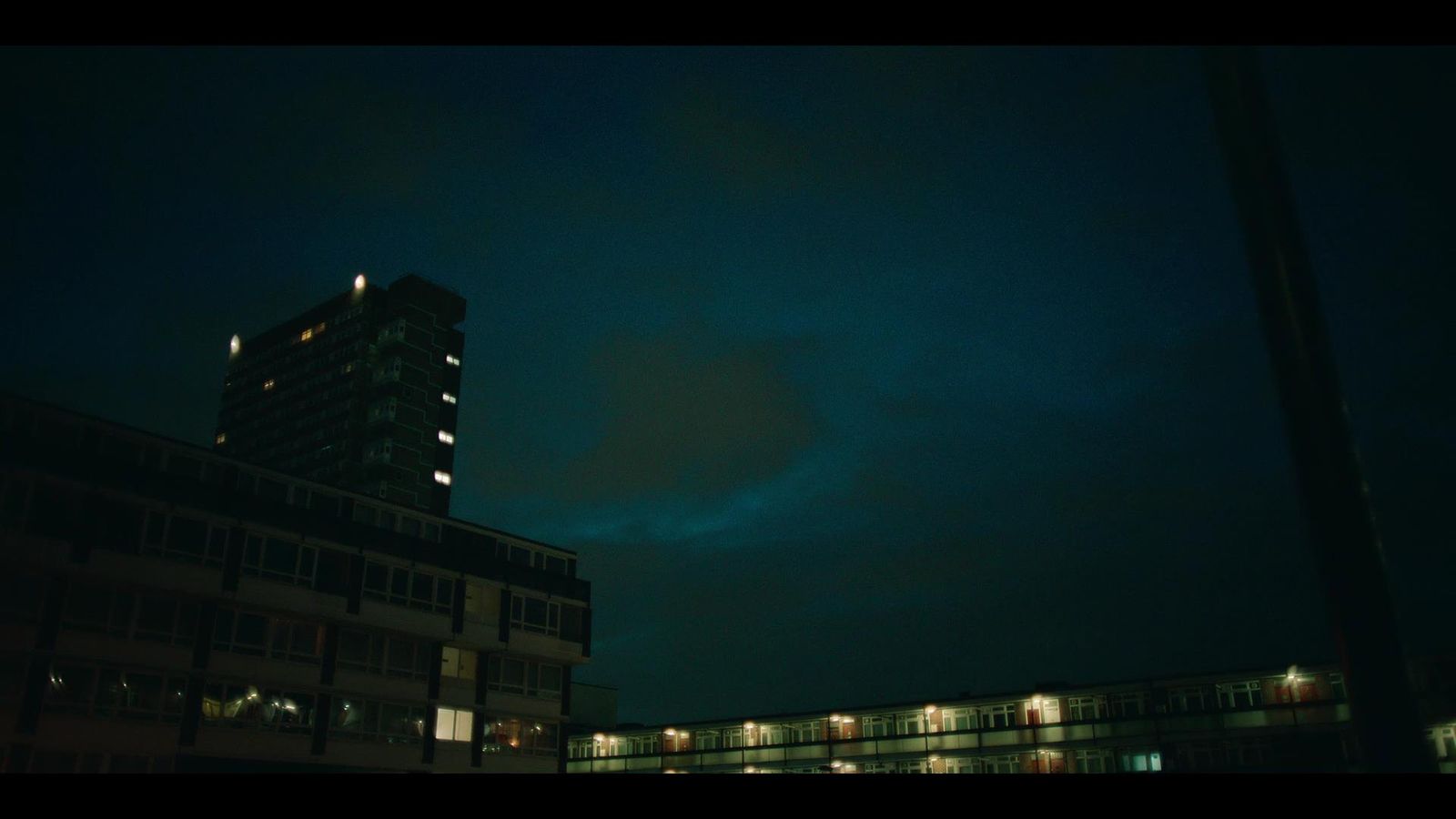 a tall building sitting next to a tall building at night