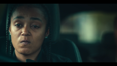 a woman with braids sitting in a car