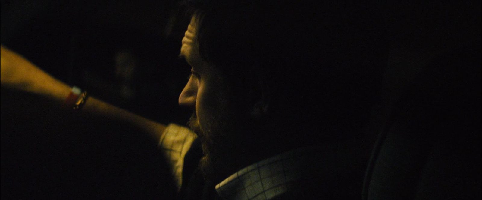 a man sitting in a car in the dark