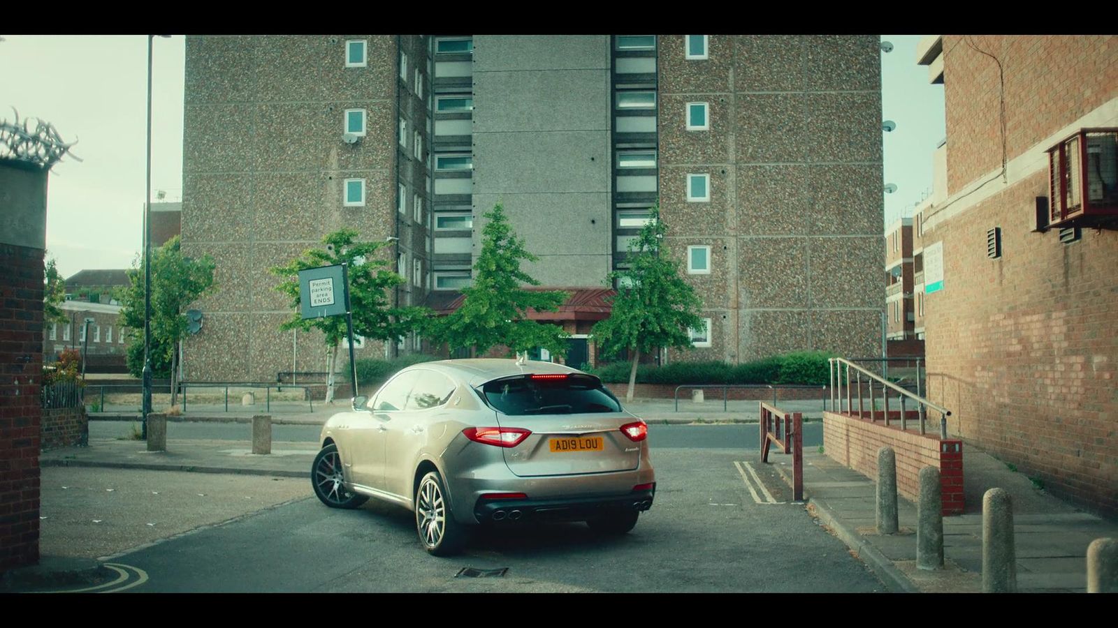 a silver car parked in front of a tall building