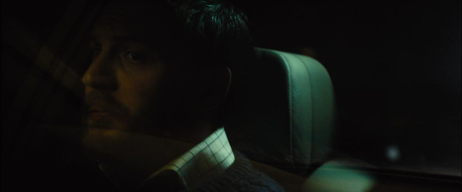 a man sitting in a car in the dark