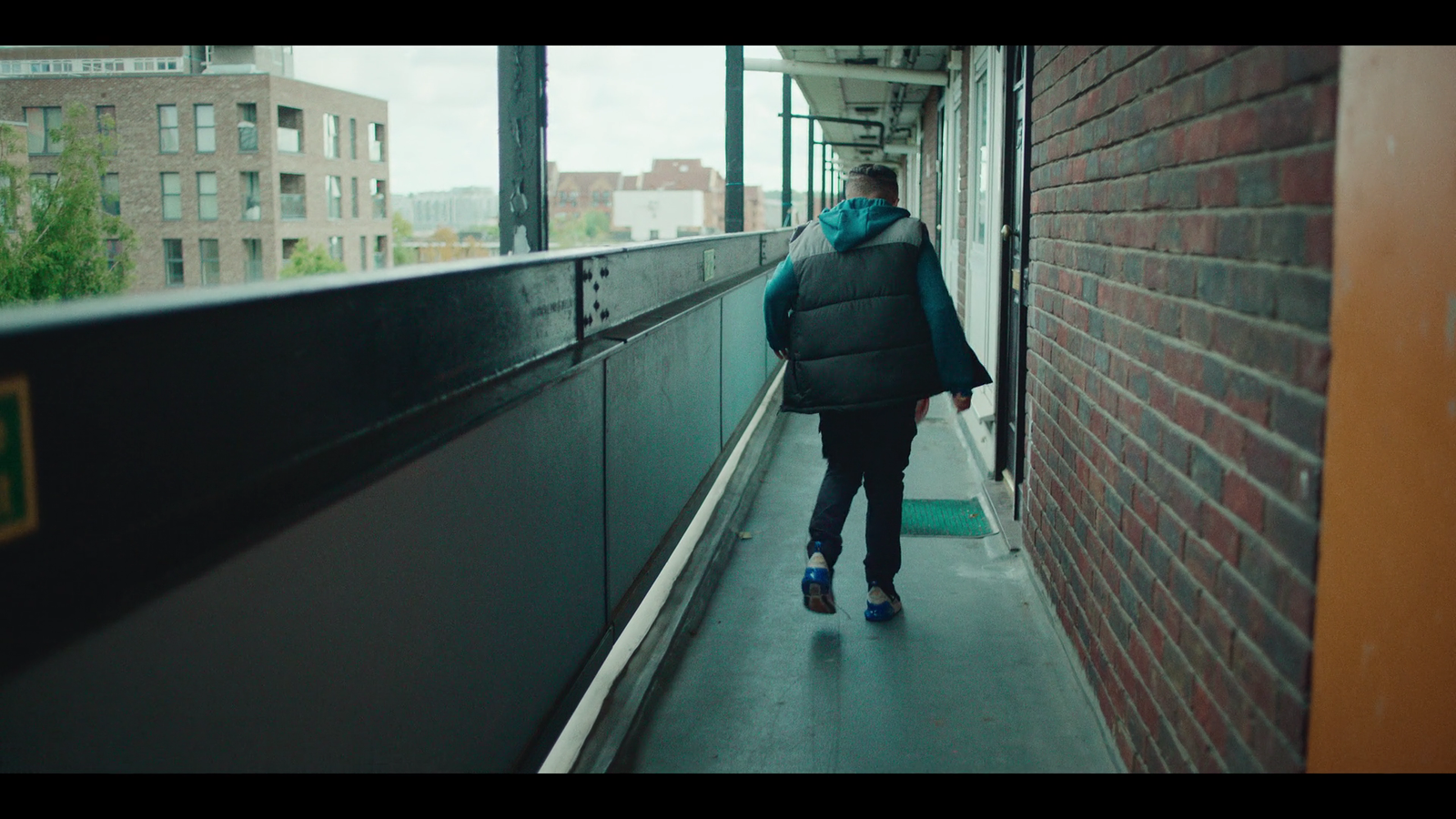 a person walking down a sidewalk next to a brick building