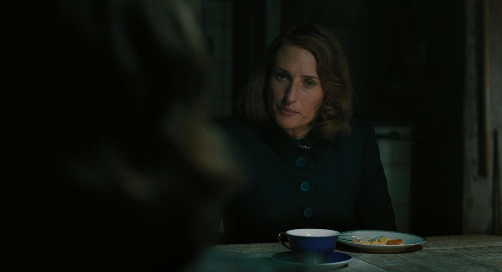 a woman sitting at a table with a plate of food