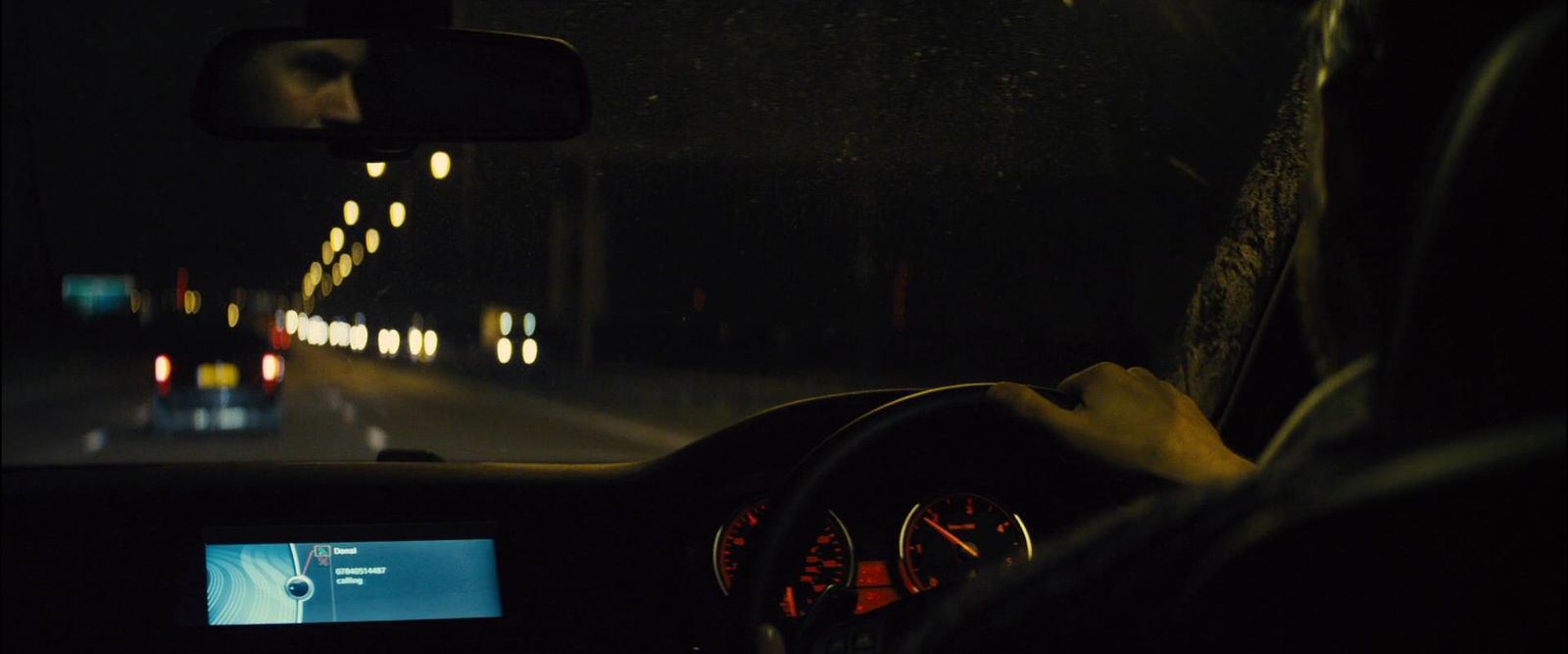 a man driving a car in the dark at night