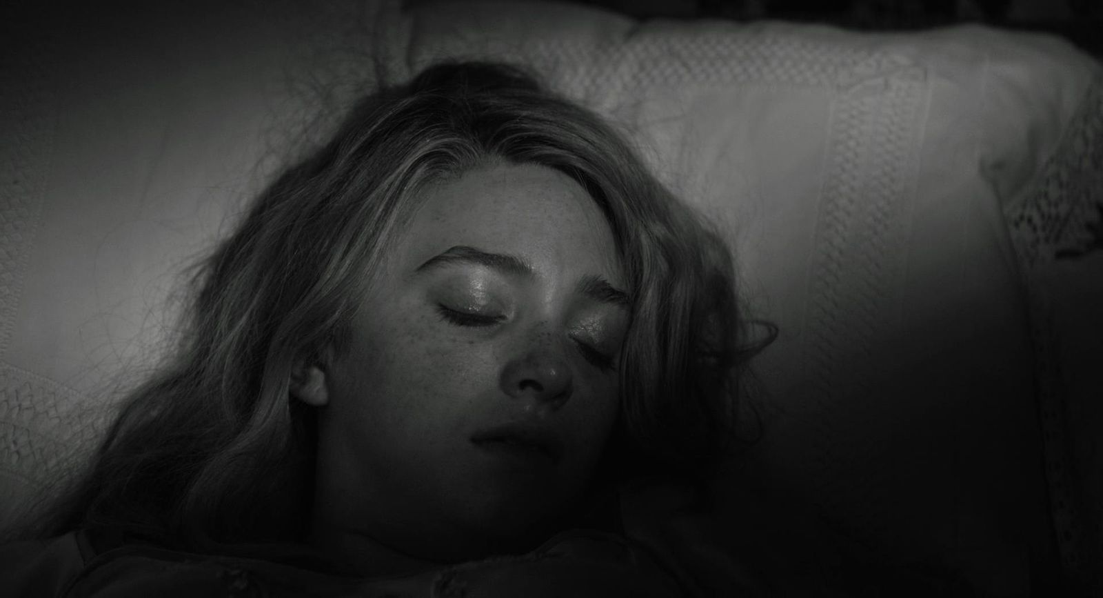 a woman laying in bed with her eyes closed