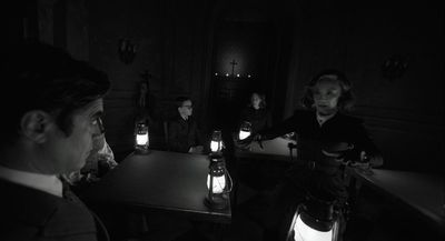 a group of people sitting at a table in a dark room