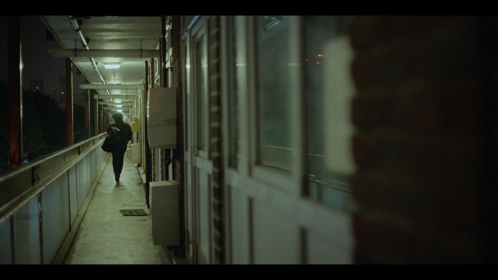 a person walking down a hallway next to a building