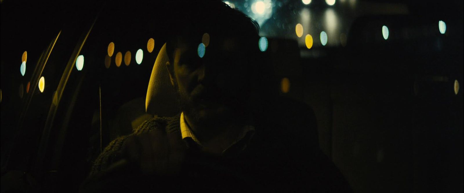 a man sitting in the back of a car at night