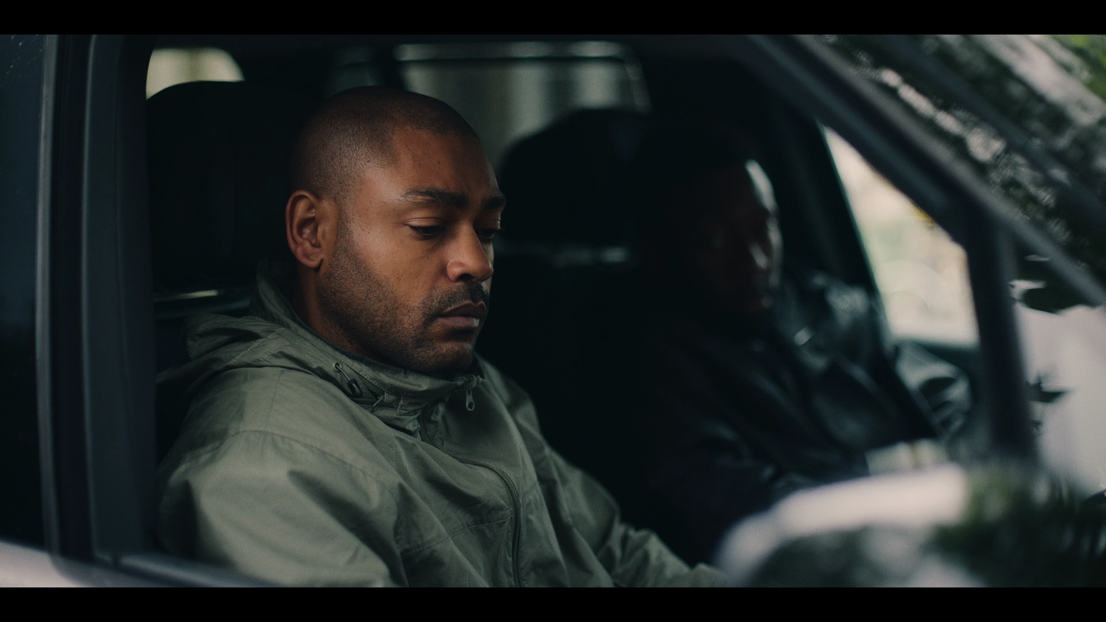 a man sitting in a car with his eyes closed