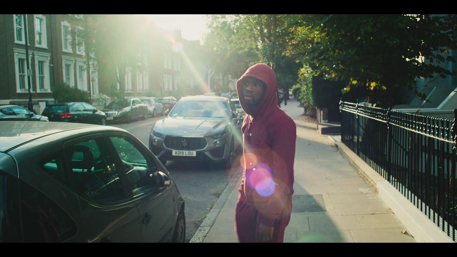 a man in a red hoodie walking down the street