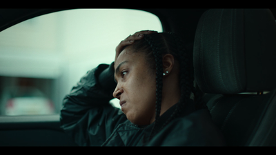 a woman with braids sitting in a car