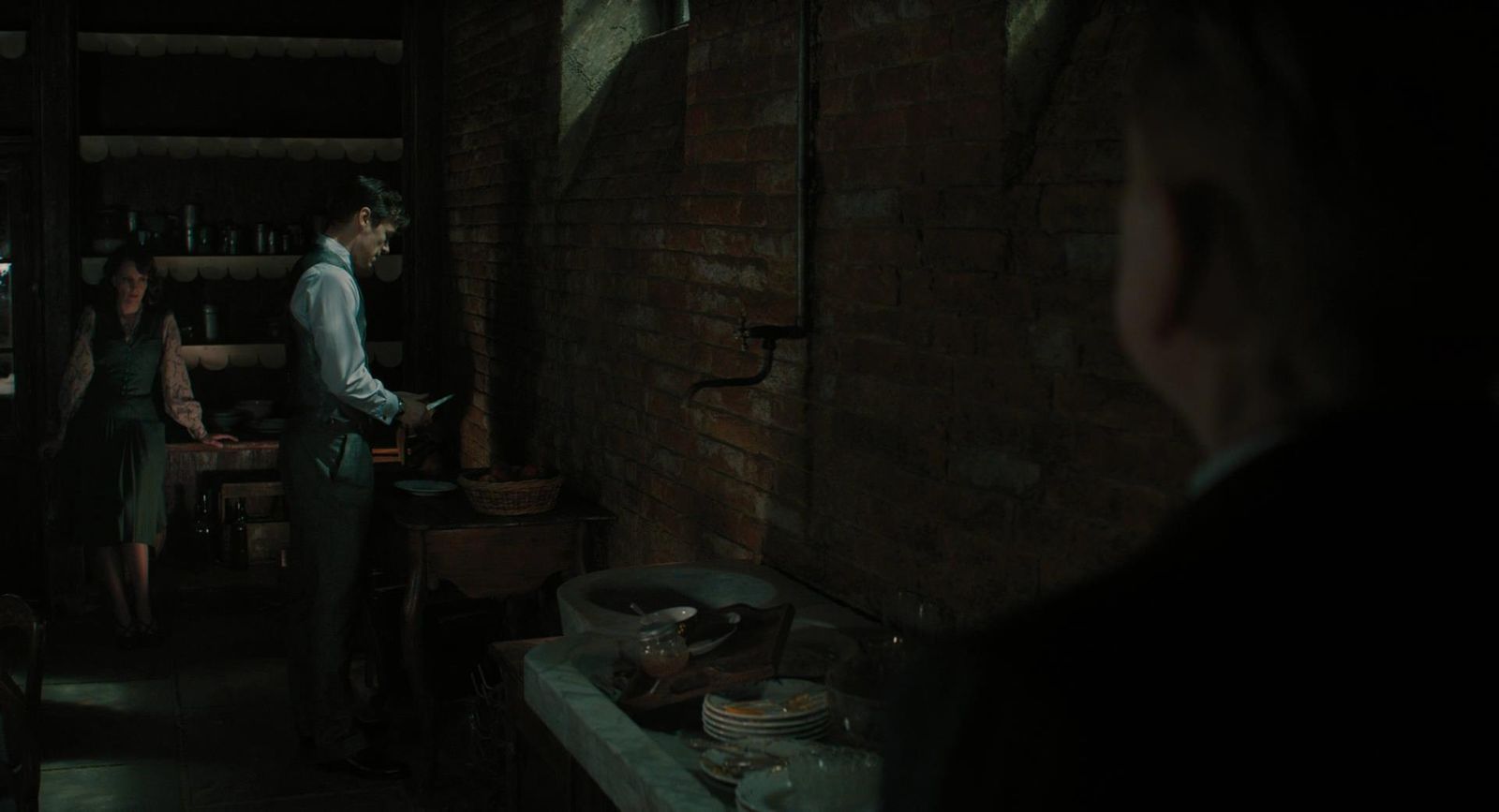 a man standing in a kitchen next to a woman