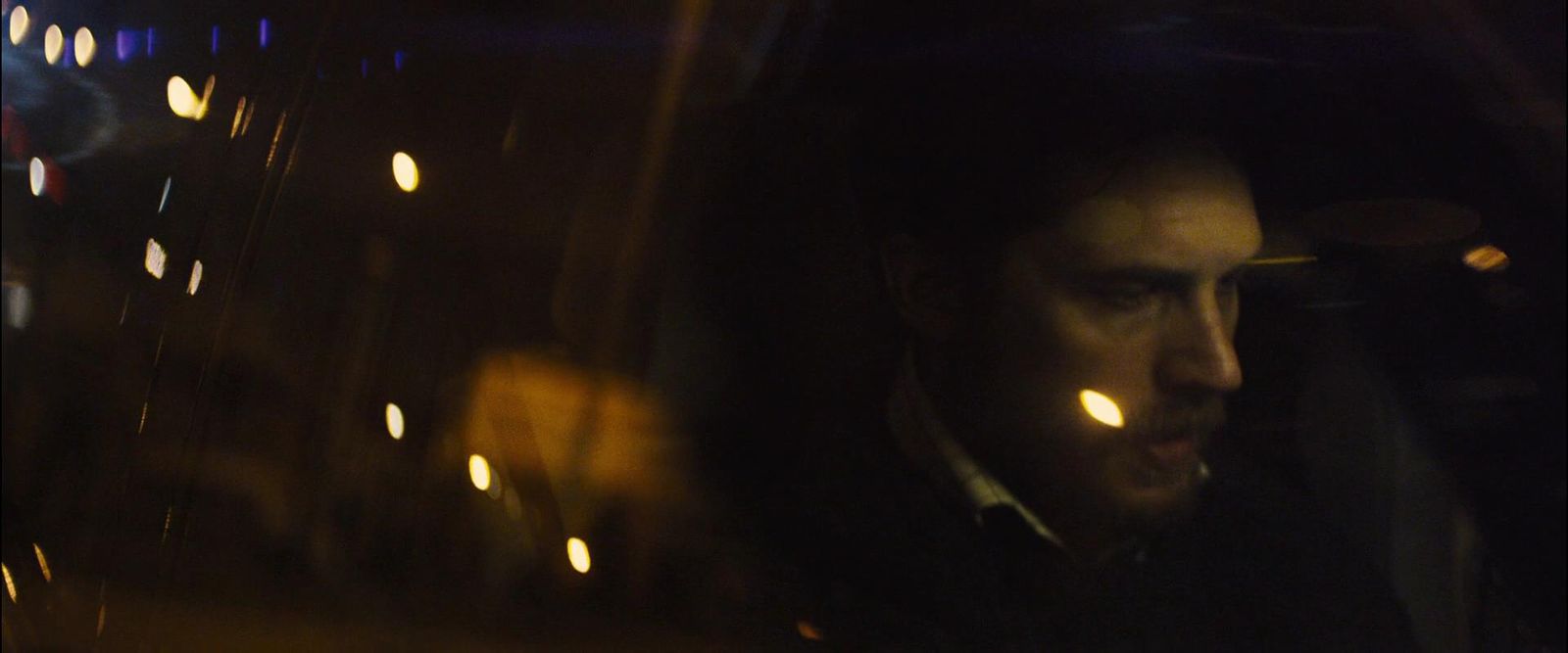 a man driving a car at night in the dark