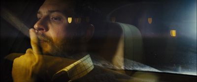 a man sitting in a car looking out the window