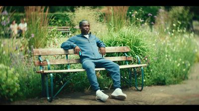 a man sitting on a bench in a garden