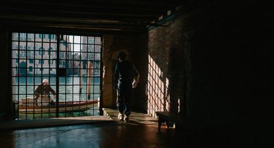 a man standing in front of a window in a dark room