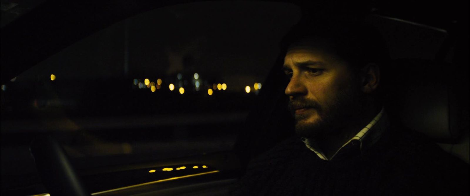 a man sitting in a car at night