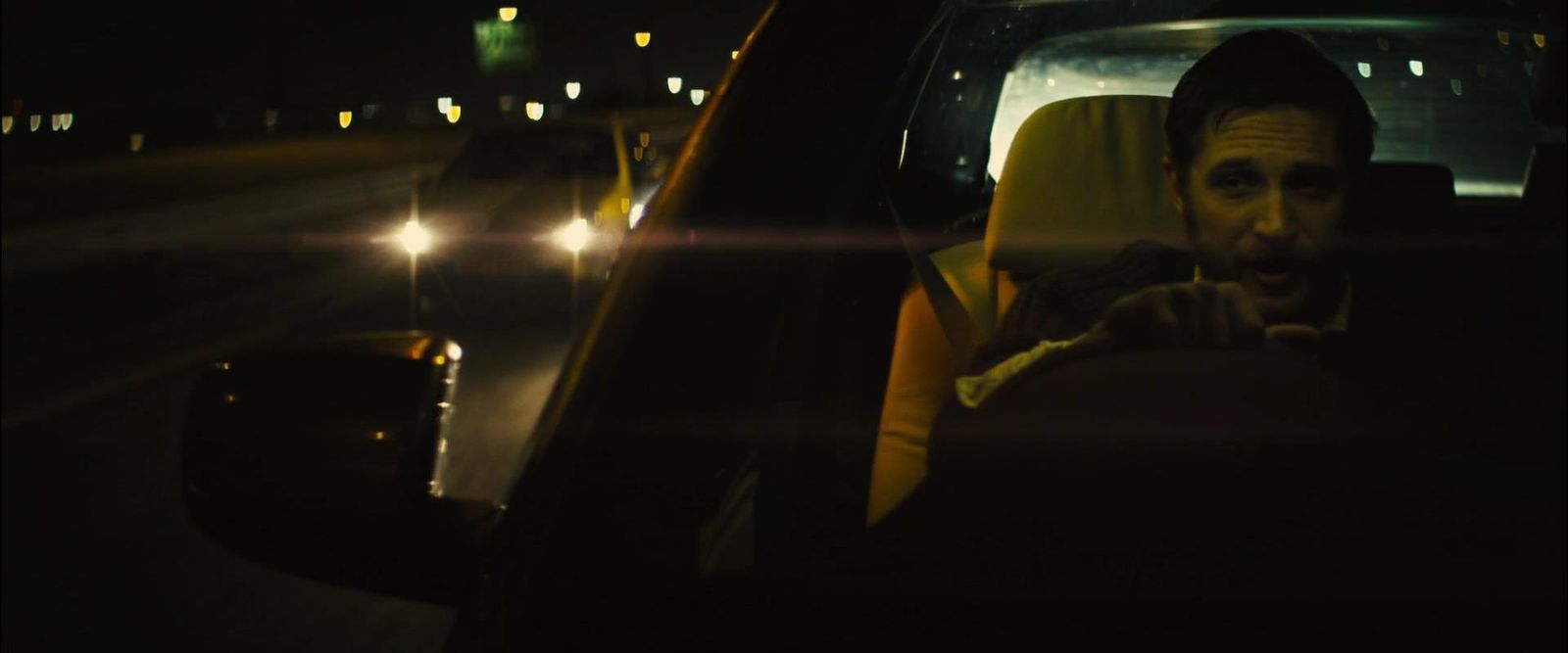 a man sitting in a car at night