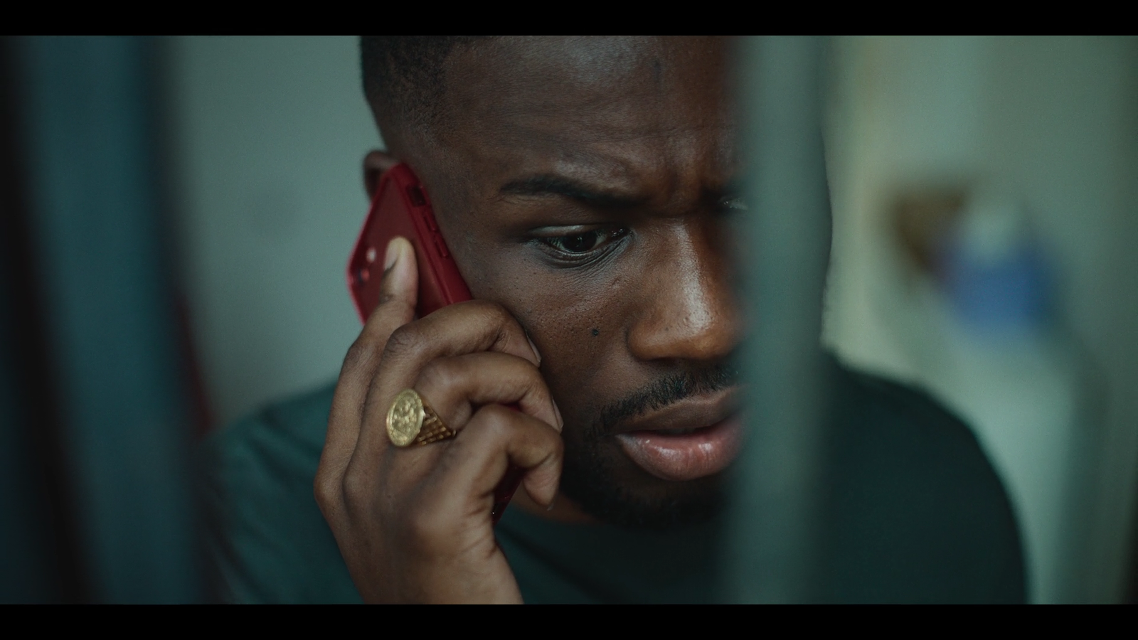 a man talking on a red cell phone