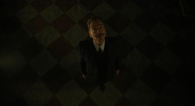 a man in a suit standing in a dark room