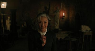 an older woman standing in a dark room