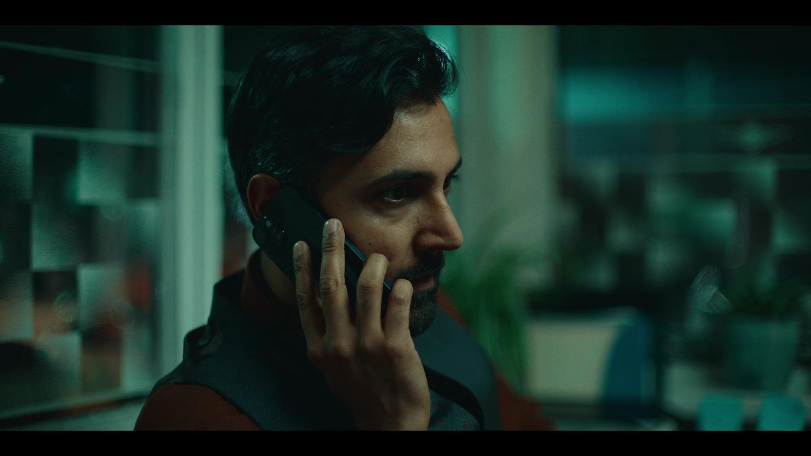 a man talking on a cell phone in a dark room