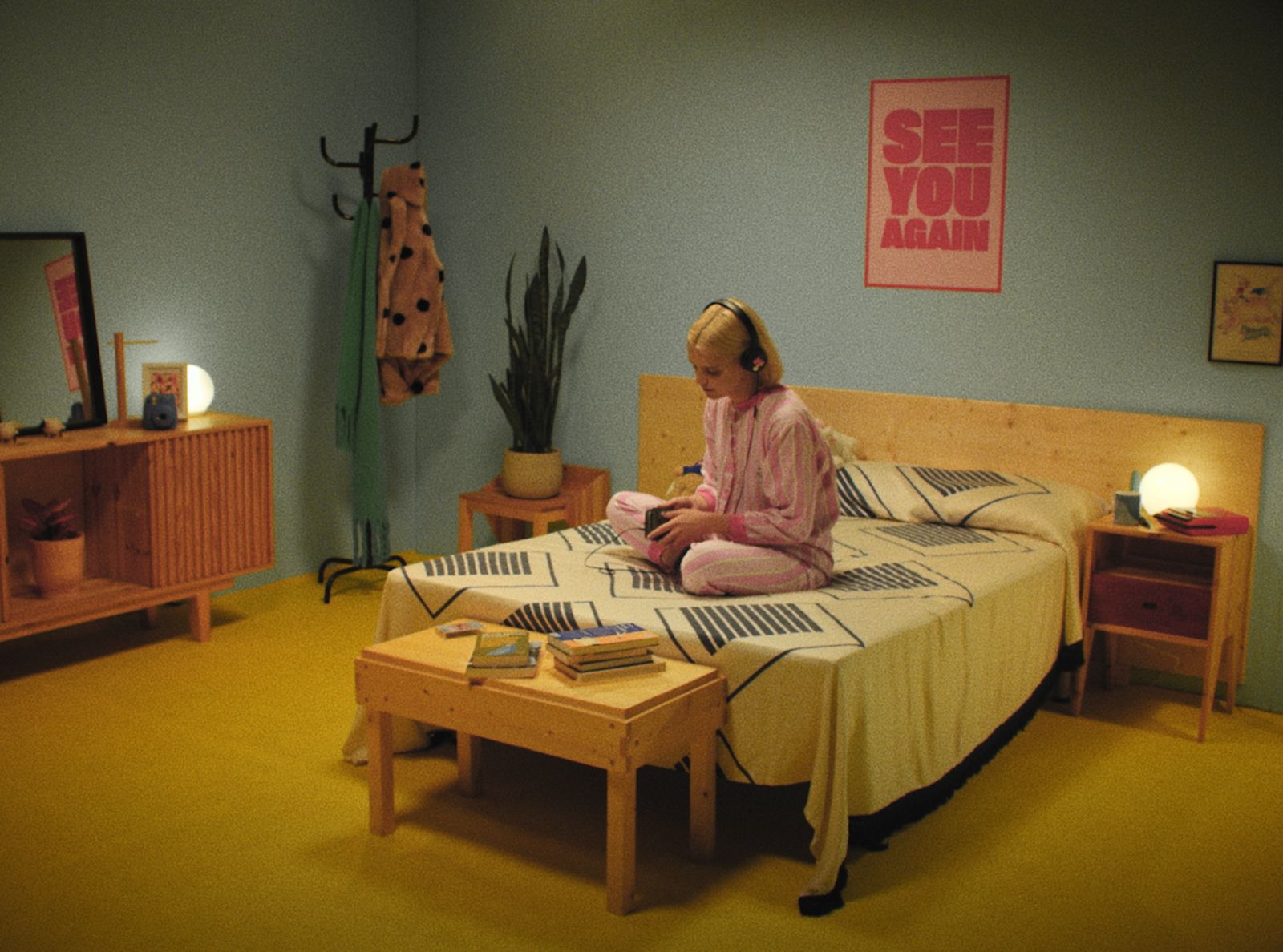 a little girl sitting on a bed in a room