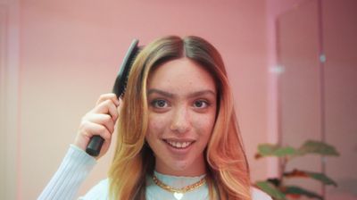 a woman holding a hair brush in her hand