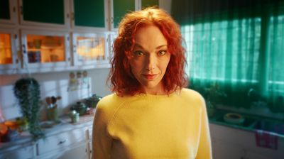 a woman with red hair standing in a kitchen