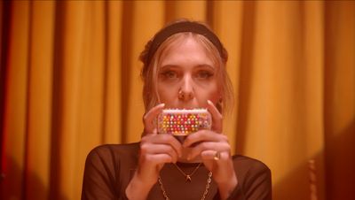 a woman taking a picture of herself holding a candy bar