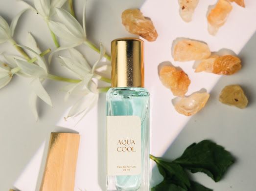 a bottle of aqua cool next to some flowers