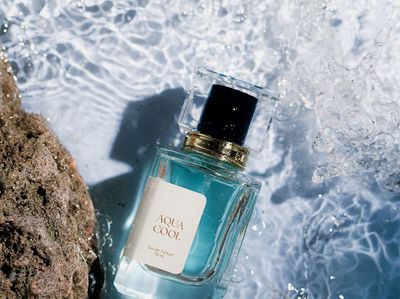 a bottle of perfume sitting on top of a rock