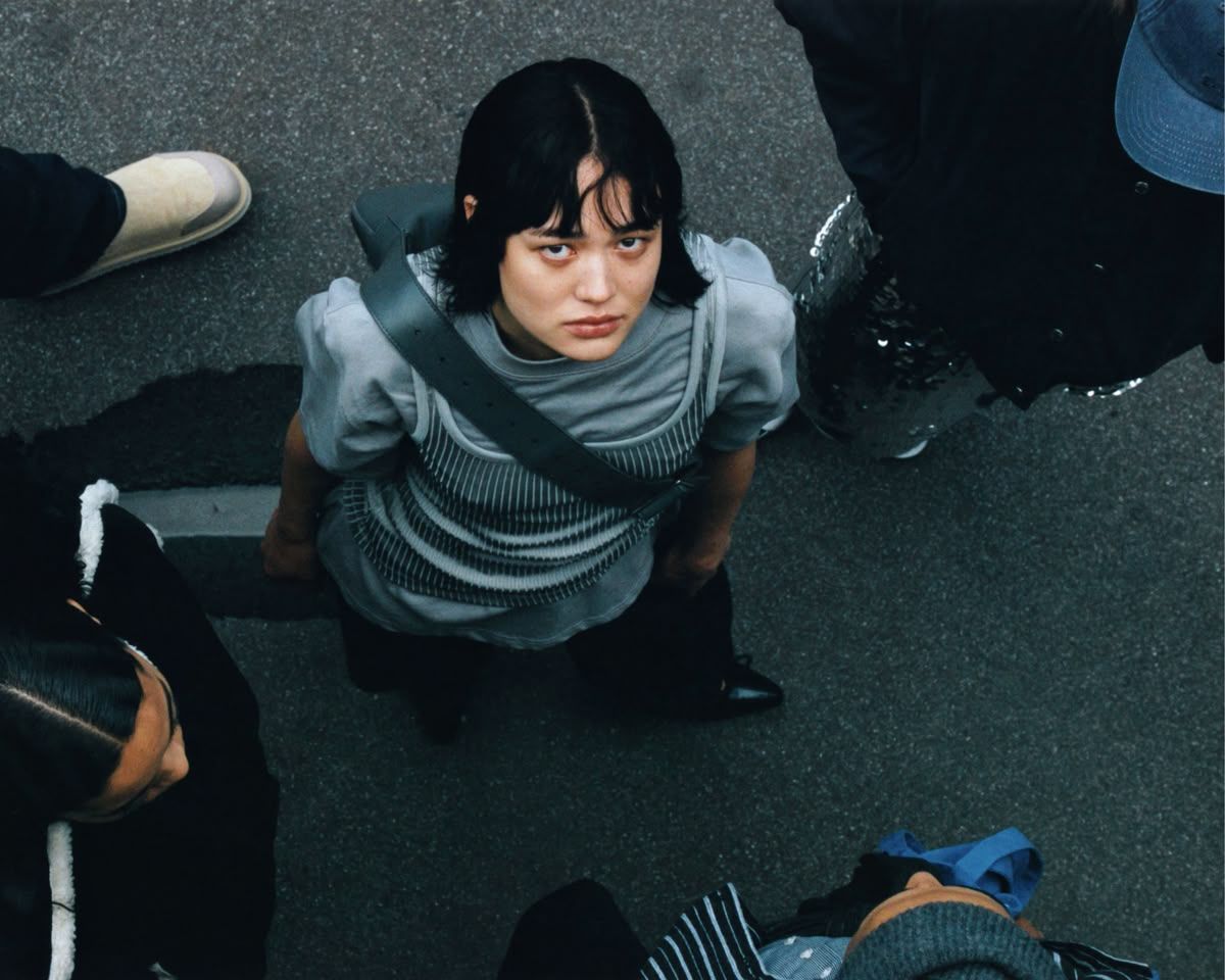 a woman sitting on the ground surrounded by other people
