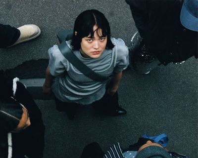 a woman sitting on the ground surrounded by other people