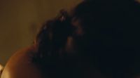 a blurry image of a woman's back with her hair in a bun