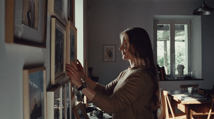 a woman looking at pictures on a wall