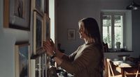 a woman looking at pictures on a wall