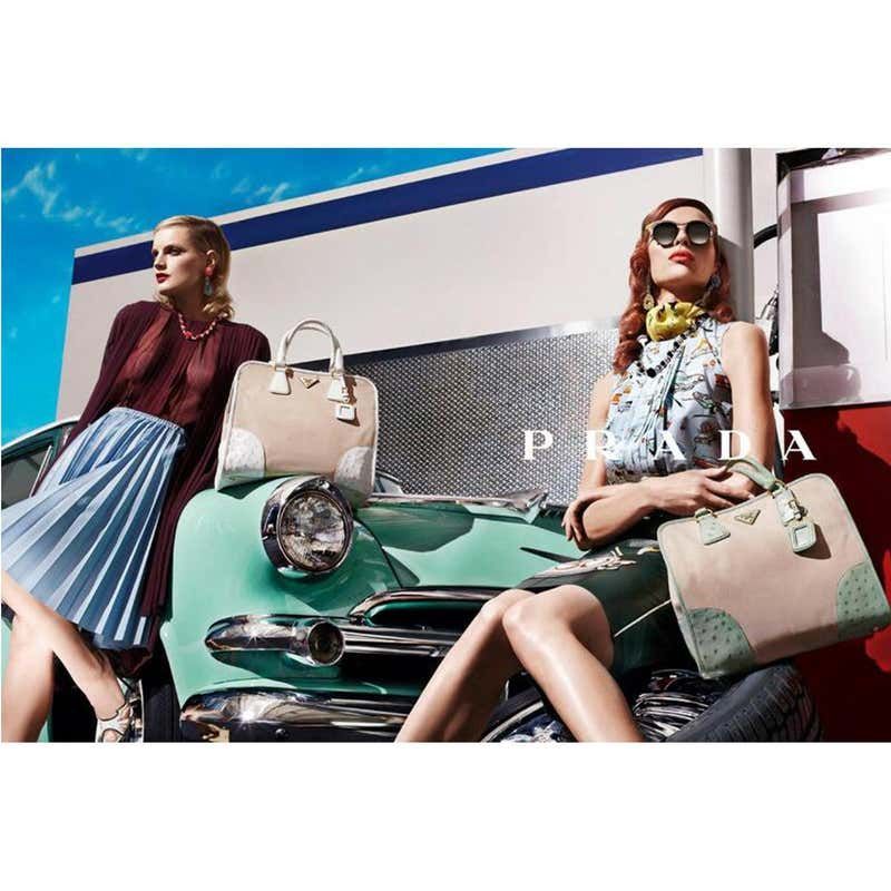 a couple of women sitting on top of a green car