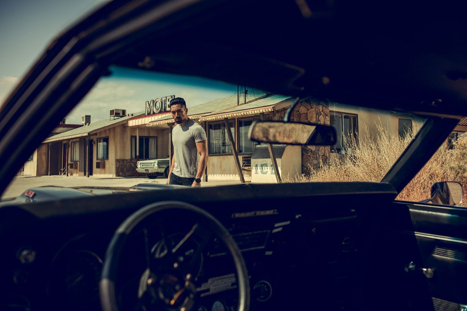 a man standing in the drivers seat of a car