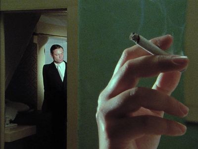 a man in a suit smoking a cigarette